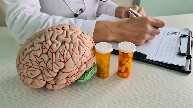 A doctor writing on a clipboard next to a brain, examining medical records and analyzing brain functions