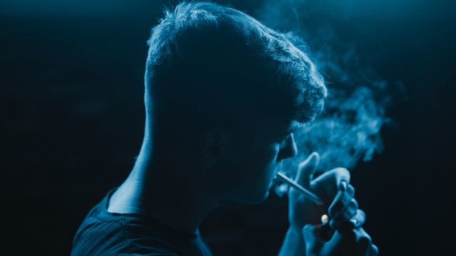 A man lighting a cigarette.