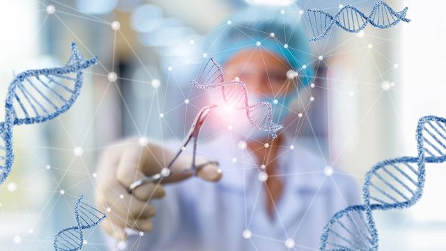 A blurred scientist pinching a small part of a DNA helix